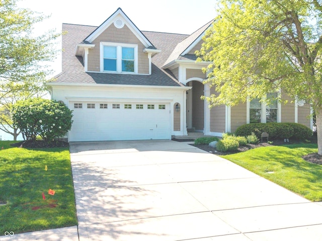 craftsman-style house featuring concrete driveway, a shingled roof, a front yard, and a garage