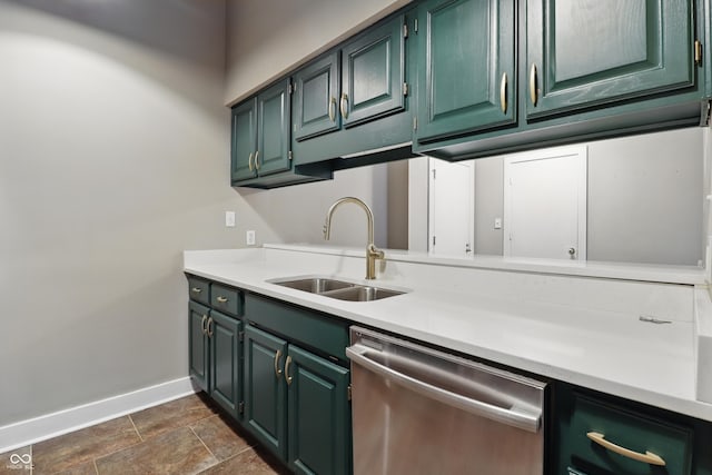 kitchen featuring dishwasher, baseboards, a sink, light countertops, and dark stone finish floors