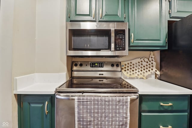 kitchen featuring stainless steel appliances, green cabinets, and light countertops