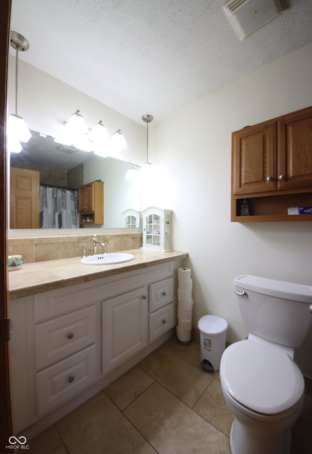 5041 Norcroft Dr, Indianapolis, IN 46221 - bathroom with tile patterned flooring, vanity, toilet, a textured ceiling, and visible vents