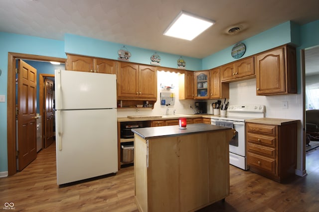 5041 Norcroft Dr, Indianapolis, IN 46221 - kitchen featuring visible vents, wood finished floors, white appliances, brown cabinets, and backsplash