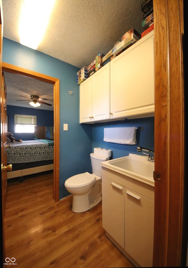 5041 Norcroft Dr, Indianapolis, IN 46221 - bathroom with a ceiling fan, a textured ceiling, wood finished floors, vanity, and toilet