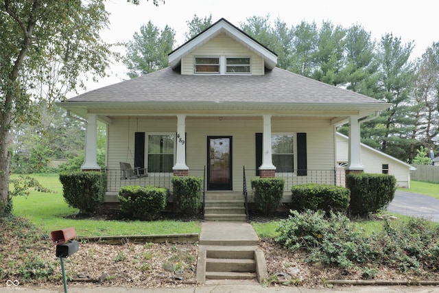 view of front of property featuring a shingled roof and covered porch
