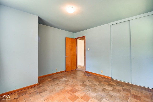 unfurnished bedroom with baseboards and a closet