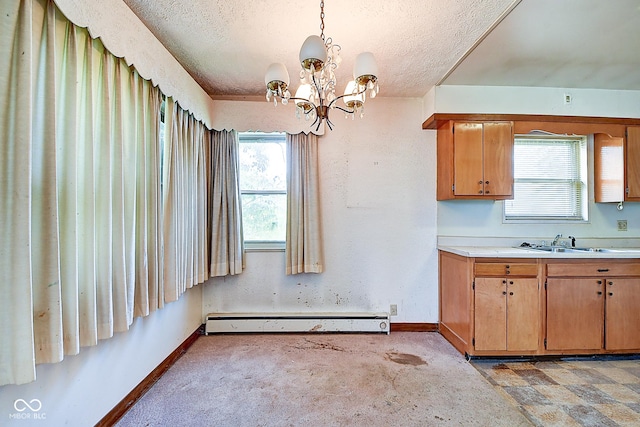 kitchen with light countertops, a textured ceiling, baseboards, and baseboard heating