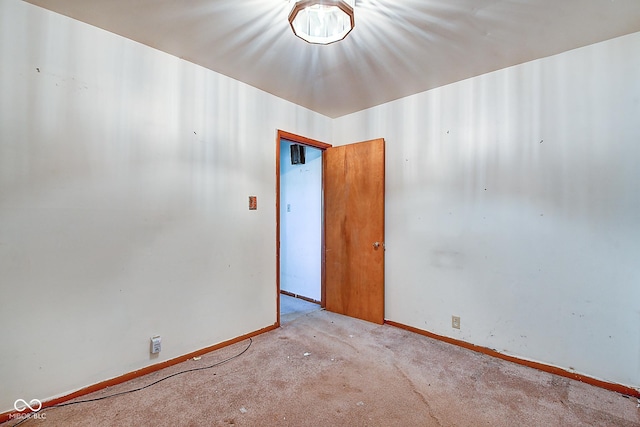 carpeted empty room featuring baseboards