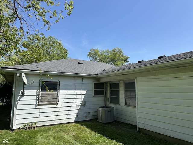 back of property with a lawn and central AC