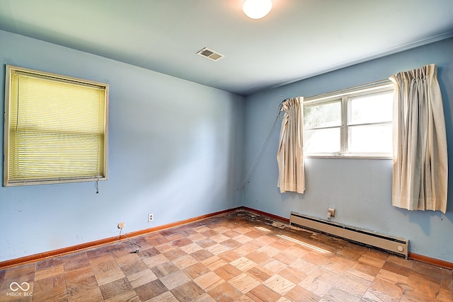 unfurnished room featuring baseboards, baseboard heating, and visible vents
