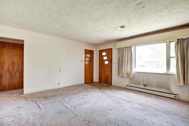 carpeted entrance foyer featuring a textured ceiling, visible vents, baseboards, and a baseboard radiator