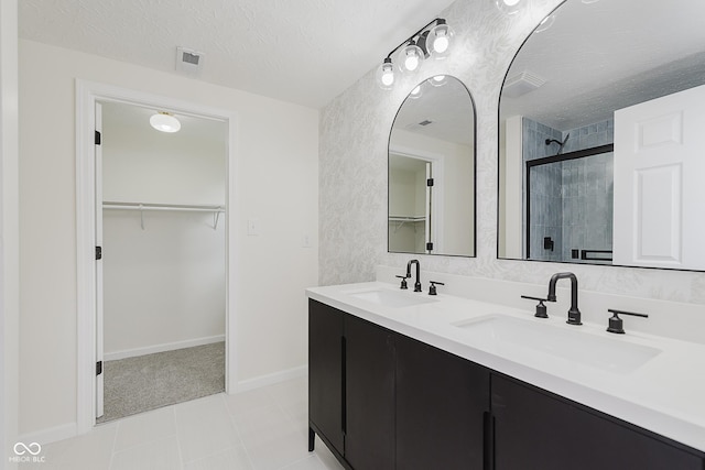 full bath featuring a sink, visible vents, a shower stall, and a spacious closet