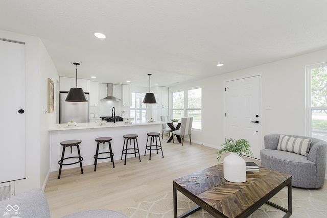 living area with light wood-type flooring, recessed lighting, and baseboards