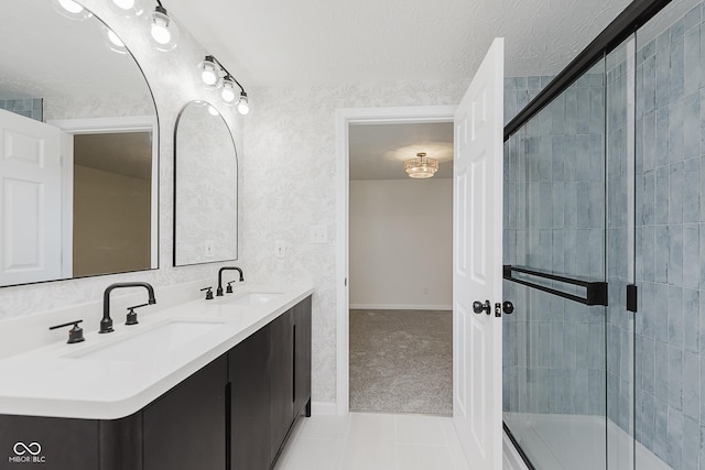 full bath featuring double vanity, a sink, a shower with shower door, and tile patterned flooring