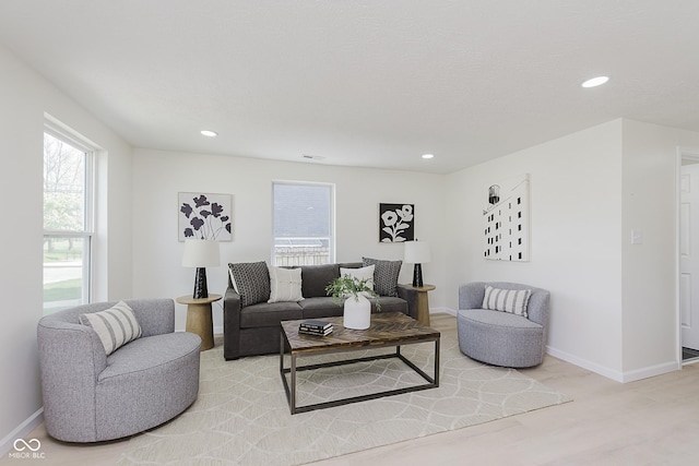 living area featuring baseboards and recessed lighting