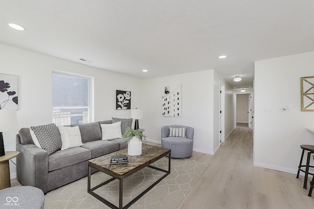 living area with recessed lighting, baseboards, light wood-type flooring, and visible vents
