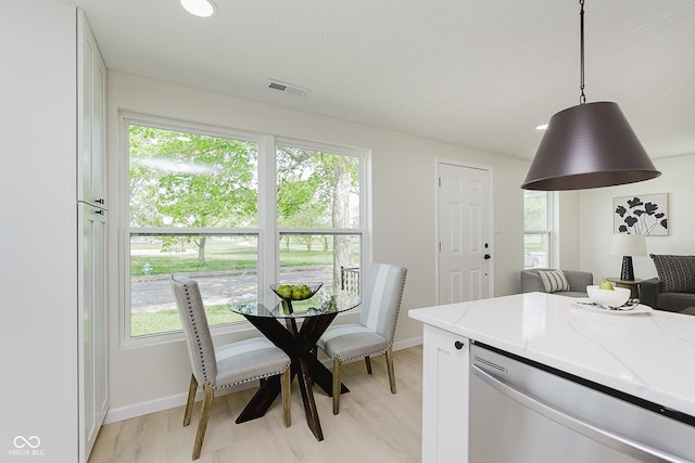 kitchen with light stone countertops, visible vents, a healthy amount of sunlight, and dishwasher