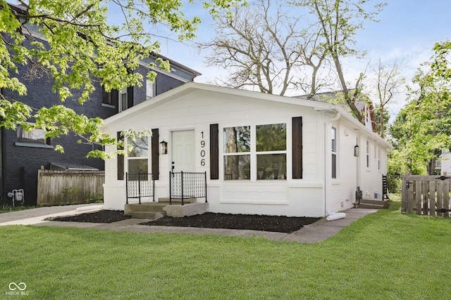 bungalow-style house featuring fence and a front lawn