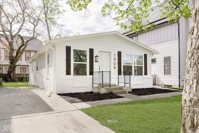 bungalow-style home with a front yard