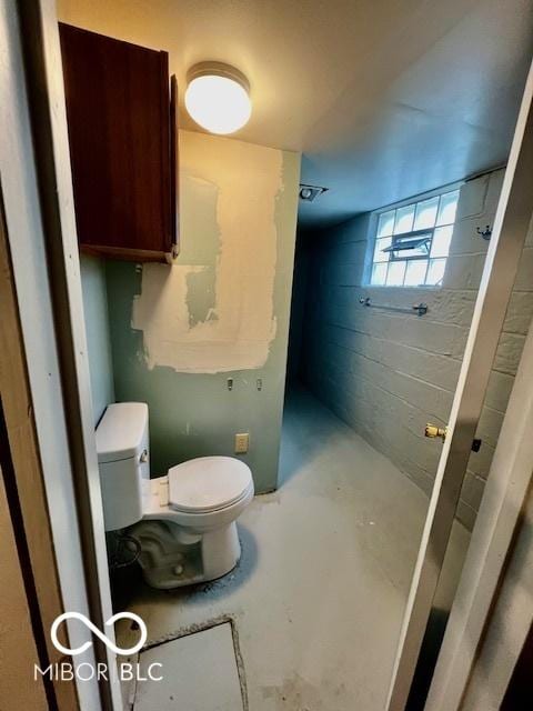 bathroom with toilet and concrete floors