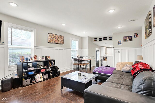 1641 Iowa St, Indianapolis, IN 46203 - living room featuring a decorative wall, wainscoting, dark wood-style floors, and recessed lighting
