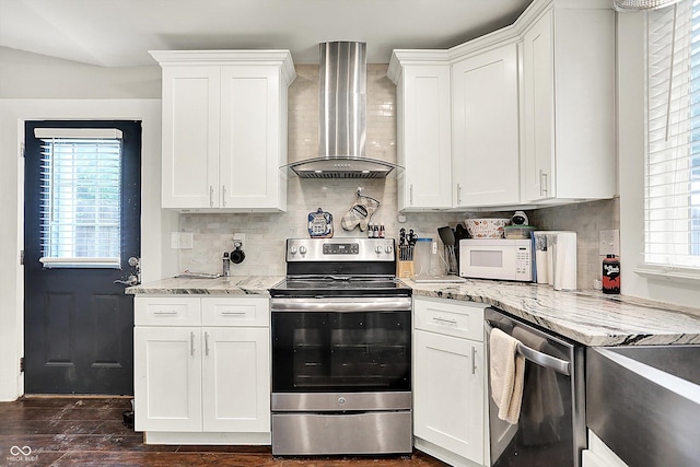 1641 Iowa St, Indianapolis, IN 46203 - kitchen with wall chimney exhaust hood, stainless steel appliances, backsplash, white cabinetry, and light stone countertops
