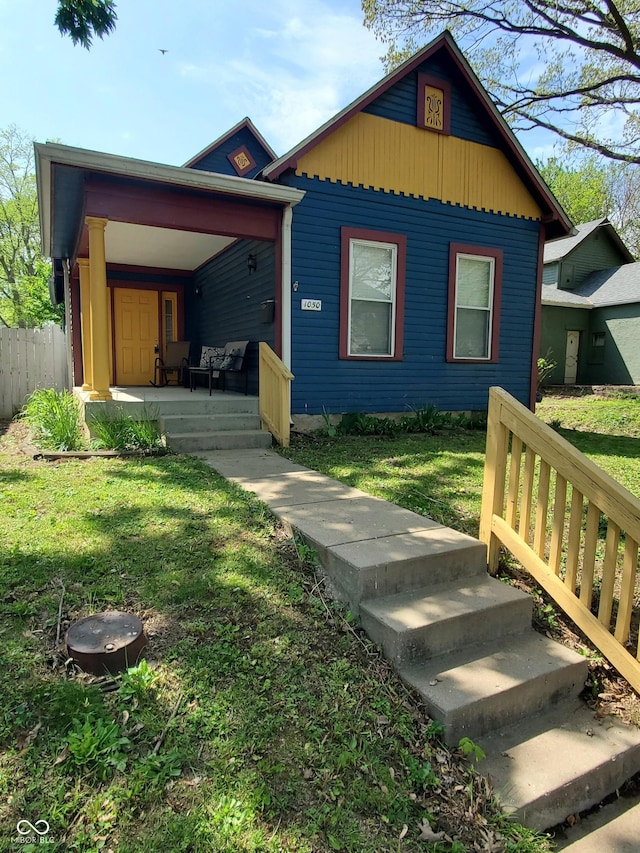 1050 Jefferson Ave, Indianapolis, IN 46201 - exterior space featuring a porch, fence, board and batten siding, and a front lawn