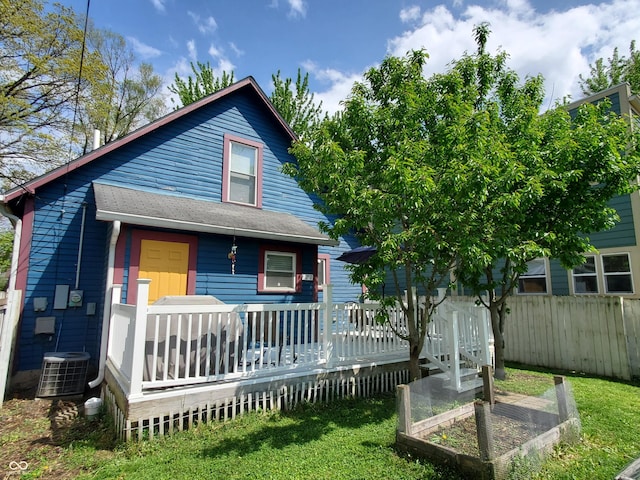 1050 Jefferson Ave, Indianapolis, IN 46201 - view of front facade featuring fence, a vegetable garden, a deck, a front yard, and cooling unit