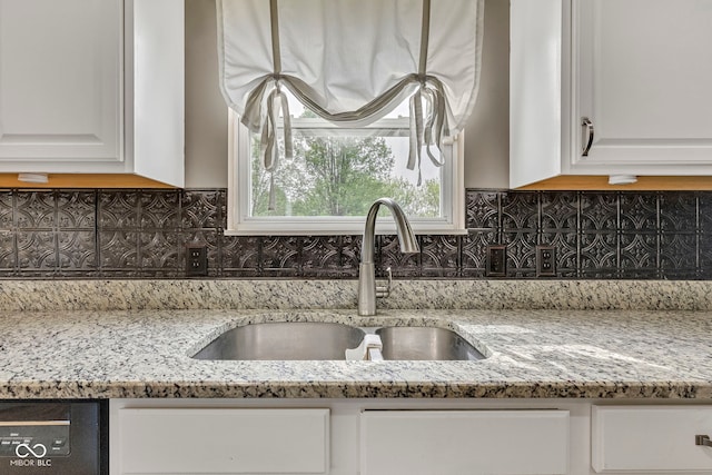 room details featuring a sink, white cabinetry, light stone countertops, dishwasher, and decorative backsplash