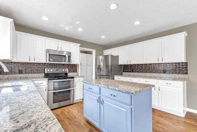 kitchen featuring white cabinets, backsplash, stainless steel appliances, and a sink