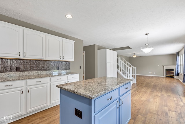 kitchen with white cabinets, a textured ceiling, and blue cabinets