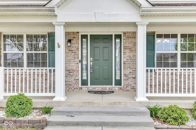property entrance featuring brick siding and covered porch