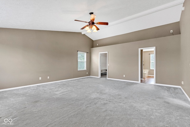 empty room featuring a ceiling fan, baseboards, high vaulted ceiling, and carpet floors