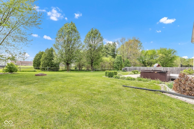 view of yard with a hot tub and a fenced backyard