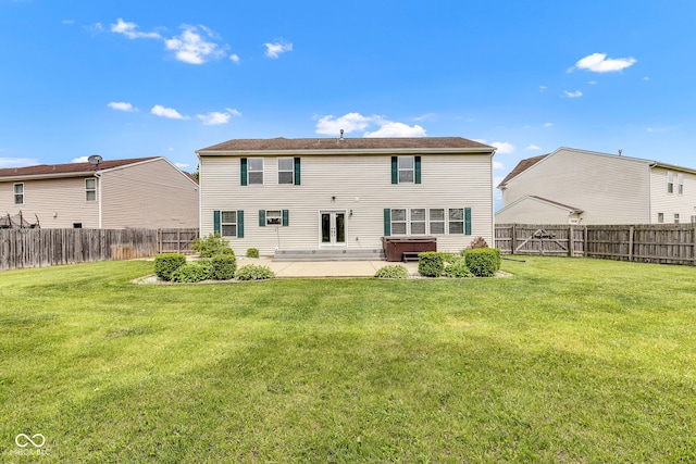 back of property featuring a fenced backyard, a patio, french doors, and a lawn