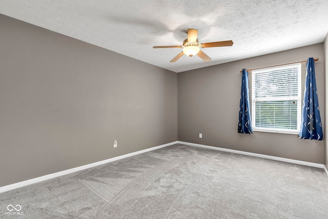 carpeted spare room featuring a textured ceiling, baseboards, and a ceiling fan