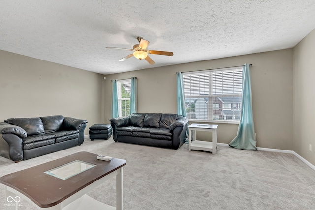 living area featuring a textured ceiling, baseboards, a ceiling fan, and carpet floors
