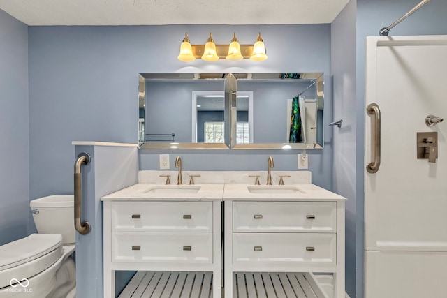 bathroom featuring toilet, a shower with curtain, double vanity, and a sink