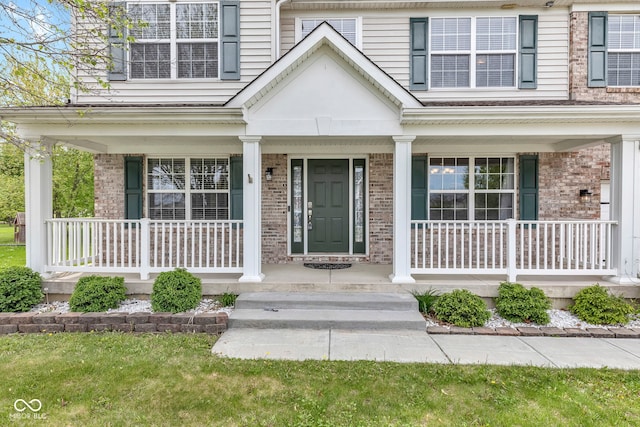 property entrance featuring a porch and brick siding