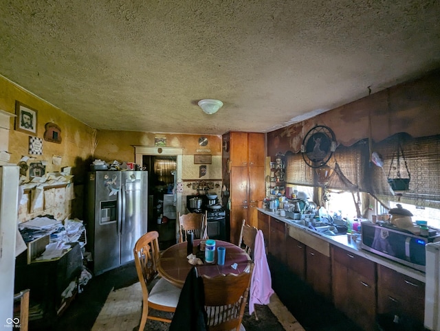 kitchen featuring a textured ceiling, appliances with stainless steel finishes, and a sink
