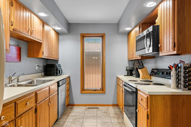 kitchen featuring appliances with stainless steel finishes, a sink, light countertops, baseboards, and light tile patterned floors