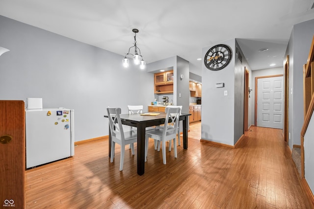 dining area with recessed lighting, baseboards, light wood finished floors, and a notable chandelier
