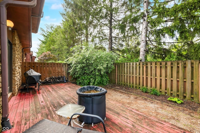 wooden terrace featuring a fenced backyard and a grill