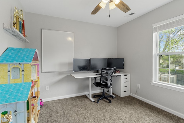 carpeted home office featuring baseboards, ceiling fan, and visible vents