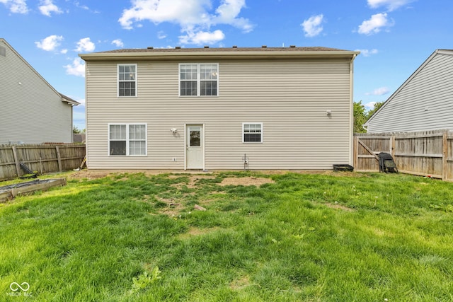 back of property featuring a lawn and a fenced backyard