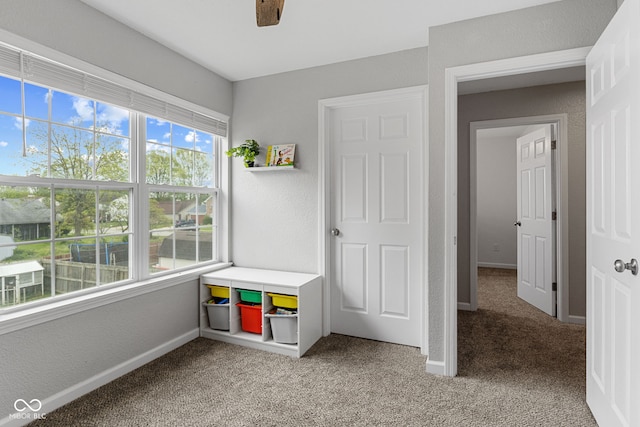 playroom featuring baseboards, light colored carpet, and a textured wall