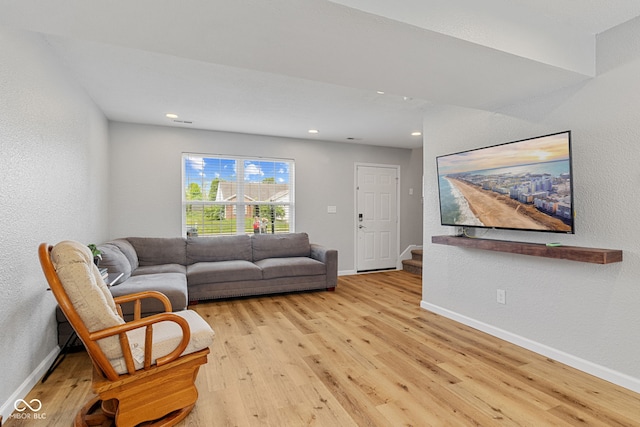 living area with light wood-type flooring, recessed lighting, baseboards, and stairs
