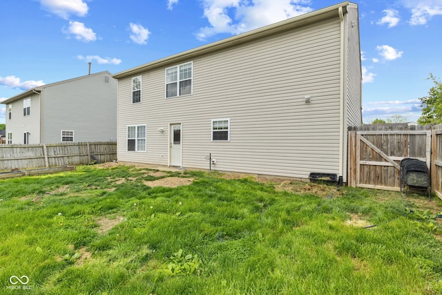rear view of property with a lawn and a fenced backyard