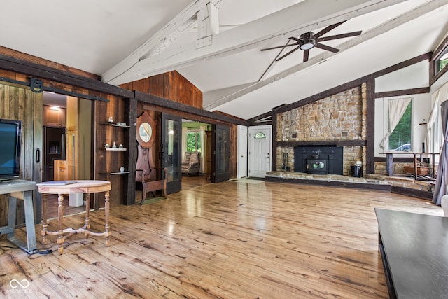 1686 Borders Rd, Nashville, IN 47448 - unfurnished living room featuring beamed ceiling, wood finished floors, ceiling fan, high vaulted ceiling, and a fireplace