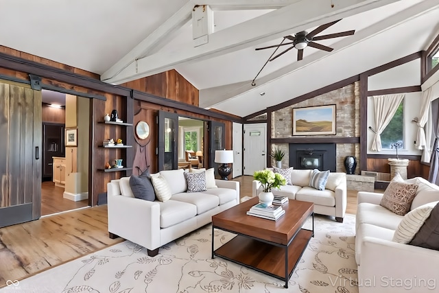 1686 Borders Rd, Nashville, IN 47448 - living room with beamed ceiling, light wood-style floors, ceiling fan, a barn door, and high vaulted ceiling