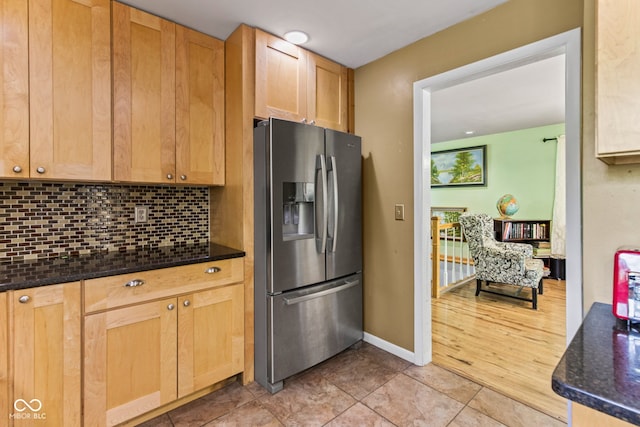 1686 Borders Rd, Nashville, IN 47448 - kitchen featuring stainless steel refrigerator with ice dispenser, decorative backsplash, baseboards, light brown cabinets, and dark stone counters