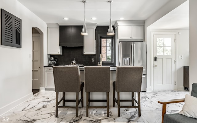 5124 N Capitol Ave, Indianapolis, IN 46208 - kitchen featuring plenty of natural light, marble finish floor, custom exhaust hood, and a breakfast bar